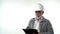 A bearded elderly pensioner man in a construction helmet writes annotations with a pen on a writing board on a white