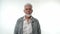 A bearded elderly pensioner man shows positive smiling emotions on a white background.