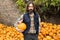 Bearded farmer with pumpkin on a background of a pile of pumpkins