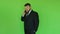 Bearded fat businessman in black suit talking on phone. Green chromakey. Plump man solves problems by smartphone. Person