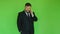 Bearded fat businessman in jacket and tie talking on smartphone. Chromakey green. Plump guy solves problems by phone