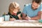 bearded father writing school homework with his child son in classroom, back to school