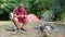 Bearded fisherman sits near a campfire in a tourist camp and preparing the bait for fishing