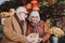 Bearded gentleman in coat giving present to wife