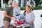 Bearded grey-haired man communicating with beautiful woman at yard sale