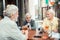 Bearded grey-haired men drinking alcohol and talking