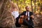 Bearded guitarist and girl sit on tree branch