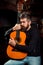 Bearded guitarist holding an acoustic guitar. Handsome bearded man playing guitar at the pub