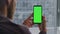 Bearded guy hands using greenscreen phone indoors. Man checking mockup screen