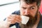 Bearded guy relaxing at cafe terrace. Coffee break concept. Guy relaxing with espresso coffee. Enjoy hot drink. Hipster