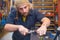 Bearded guy repairing ski in the workshop