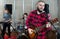 Bearded guy soloist playing guitar in studio