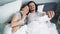Bearded guy taking selfie in bed with girlfriend using smartphone camera