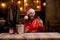 Bearded handsome Santa Claus smile and drink champagne. Christmas lights garland. Santa waiting for New Year midnight