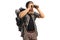 Bearded hiker with a backpack looking through binoculars