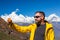 Bearded Hiker taking self portrait with telephone in Mountains