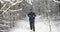 Bearded hiker walking with backpack on snowy forest