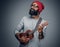 Bearded hipster male in red hat playing on ukulele.