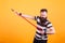 Bearded hipster in striped t-shirt using broom as if was a guitar