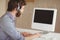 Bearded hipster working at desk with headset