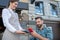 Bearded male customer paying bill with smartphone, waitress holding wireless payment machine