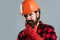 bearded male hipster in checkered shirt and laborer helmet, mechanic