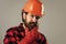 bearded male hipster in checkered shirt and laborer helmet, mechanic