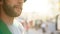 Bearded male smiling in sunlight, football fan supporting national soccer team