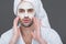 bearded man in bath robe and towel with clay mask on face,