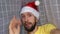 Bearded man blogger in santa hat wishes merry christmas and happy new year