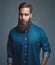 Bearded man in blue denim with serious expression