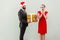 Bearded man in christmas hat give a present beautiful woman in r