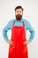 Bearded man in cook uniform. Mature shop assistant. Chef in red apron. Restaurant staff. Cooking hobby. Lots of delivery