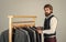 Bearded man customer looking for his size formal suit, vintage stock concept