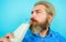 Bearded man drinks fresh milk. Handsome man in denim shirt with bottle of milk or milkshake. Enjoy organic product