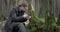 Bearded man examining green moss with loupe