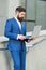 Bearded man in formal suit check up electronic mail in laptop using internet urban outdoors, email