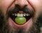 Bearded man with grape in his mouth