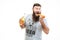 Bearded man holding bottle of beer and eating hot dog