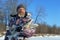 Bearded man is holding frozen fish after successful winter fishing at cold sunny day