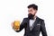 Bearded man holding a glass of beer. Hipster with beard and mustache in suit drinks beer after working day.