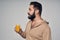 Bearded man holding a glass of orange juice