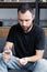 Bearded man holding glass of water and handful of pills