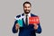 Bearded man holding passport with paper air plane and sale word sign, smiling at camera, traveling.