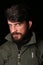 Bearded man in khaki jacket with interesting look. Close.up. Black