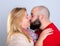 Bearded man kissing a blond woman