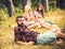 Bearded man in lumberjack shirt spending time with friends outdoors. Handsome man lying on glass in woods. Outdoor