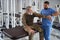 Bearded man in military clothing sits on a massage table