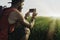 Bearded man model wearing black cap and tshirt making photo on mobile phone.Sunset in the green rice fields scenery