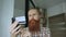 Bearded man online shopping and banking with credit card using smartphone at home